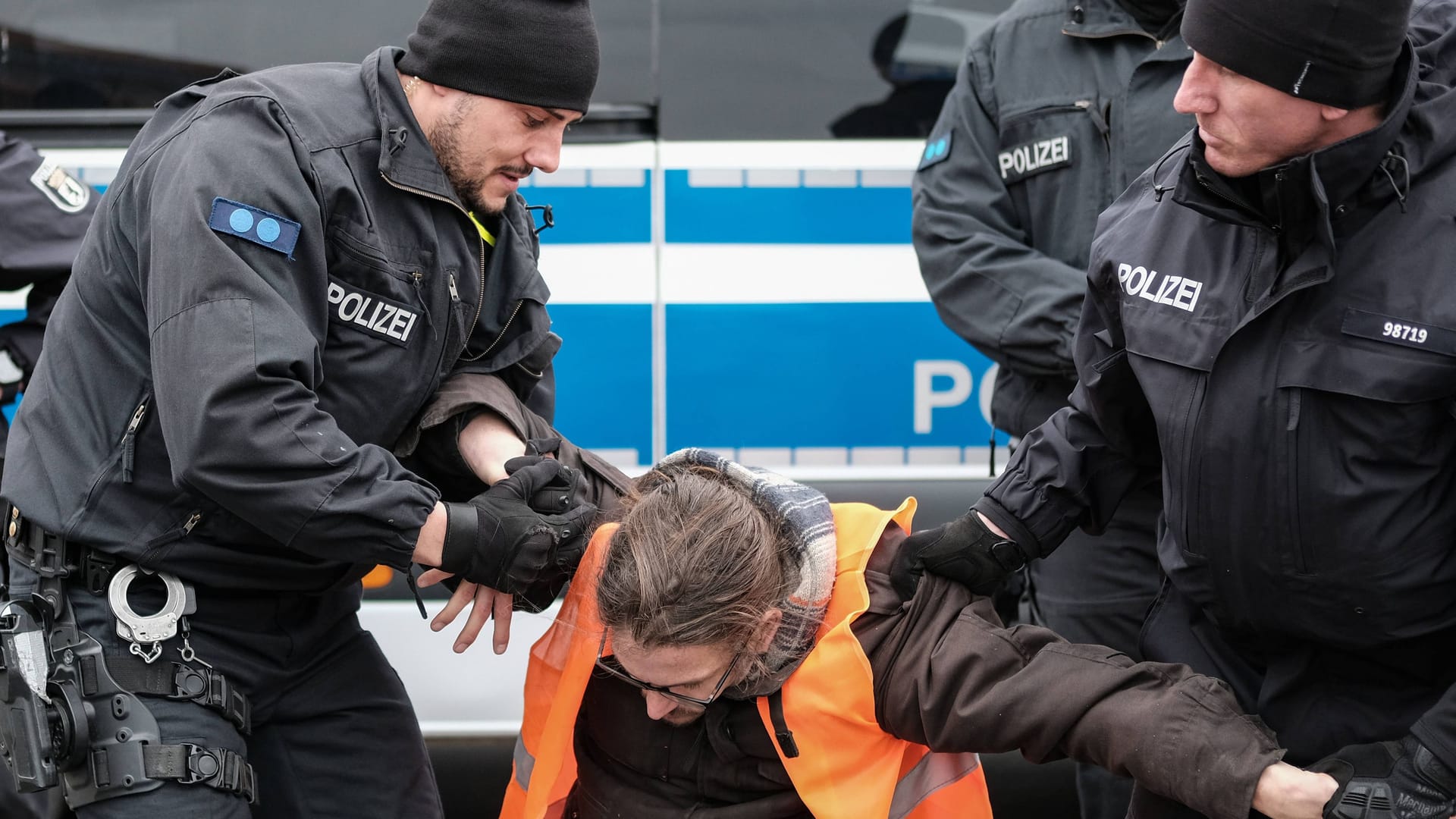 Polizisten tragen Klimaaktivisten weg (Symbolbild): Ein kursierendes Video zeigt Polizeigewalt – doch war sie gerechtfertigt?