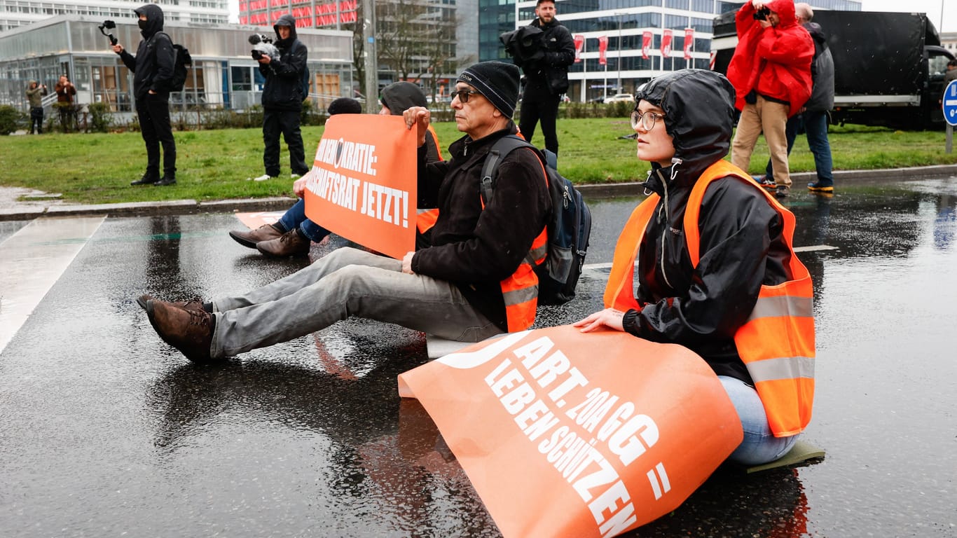 Aktivisten haben sich auf einer Straße in Berlin festgeklebt:
