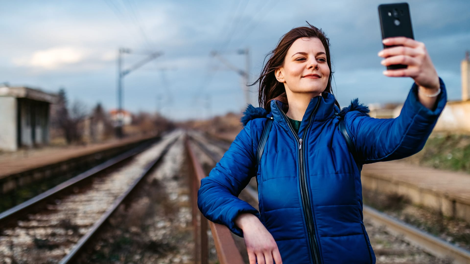 Eine junge Frau macht ein Selfie an einem Bahngleis (Archivbild): Bei Hannover und in NRW haben zwei junge Menschen bei gefährlichen Mutproben schwere Verletzungen erlitten.