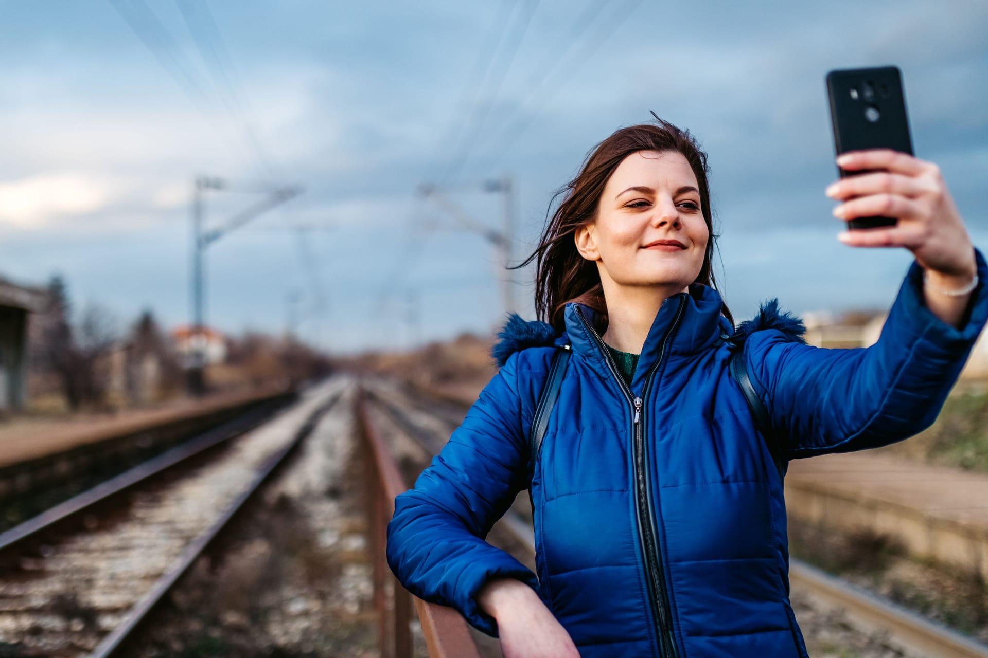 Eine junge Frau macht ein Selfie an einem Bahngleis (Archivbild): Bei Hannover und in NRW haben zwei junge Menschen bei gefährlichen Mutproben schwere Verletzungen erlitten.