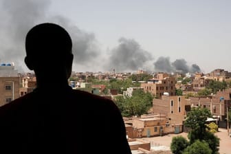 Ein Mann blickt auf die Stadt Khartum, wo schwarzer Rauch aufsteigt: Die Kämpfe in der Hauptstadt dauern an.
