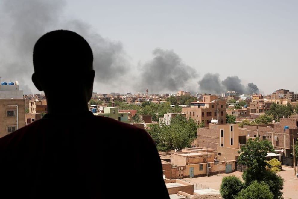 Ein Mann blickt auf die Stadt Khartum, wo schwarzer Rauch aufsteigt: Die Kämpfe in der Hauptstadt dauern an.