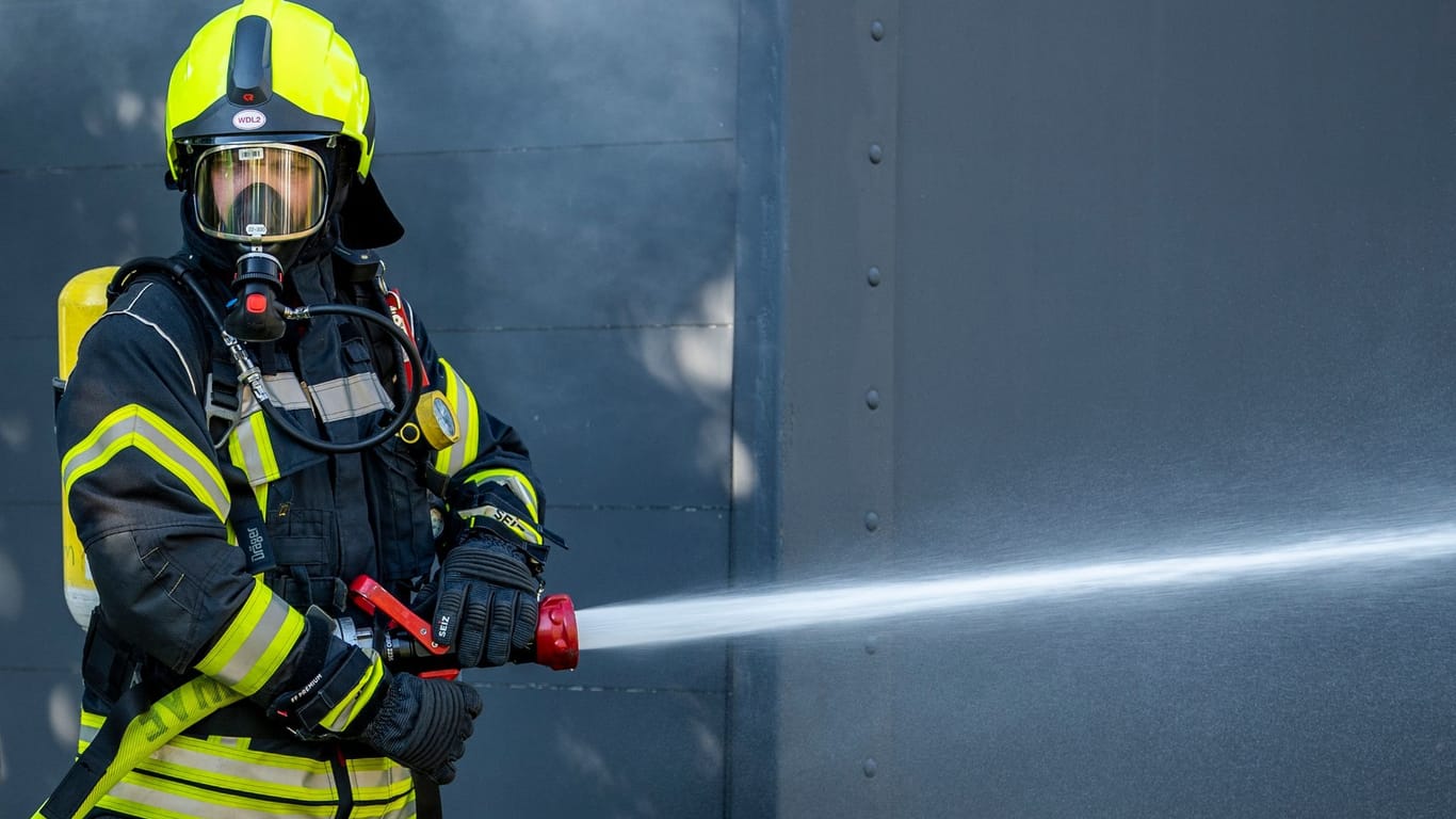 Ein Mitglied der Feuerwehr bei einem Löscheinsatz (Symbolbild): In Brandenburg hat ein Haus gebrannt.