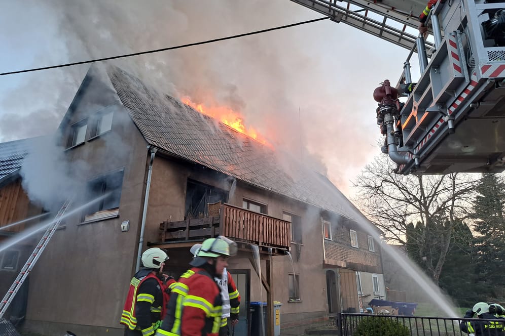 Feuerwehrleute löschen ein Feuer in Neukirch: Die Bewohner retteten sich über den Balkon.