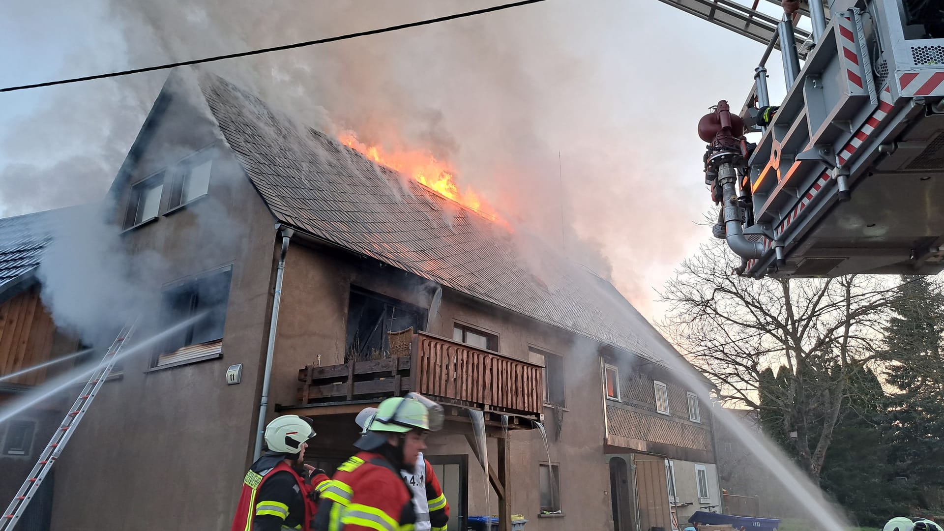 Feuerwehrleute löschen ein Feuer in Neukirch: Die Bewohner retteten sich über den Balkon.