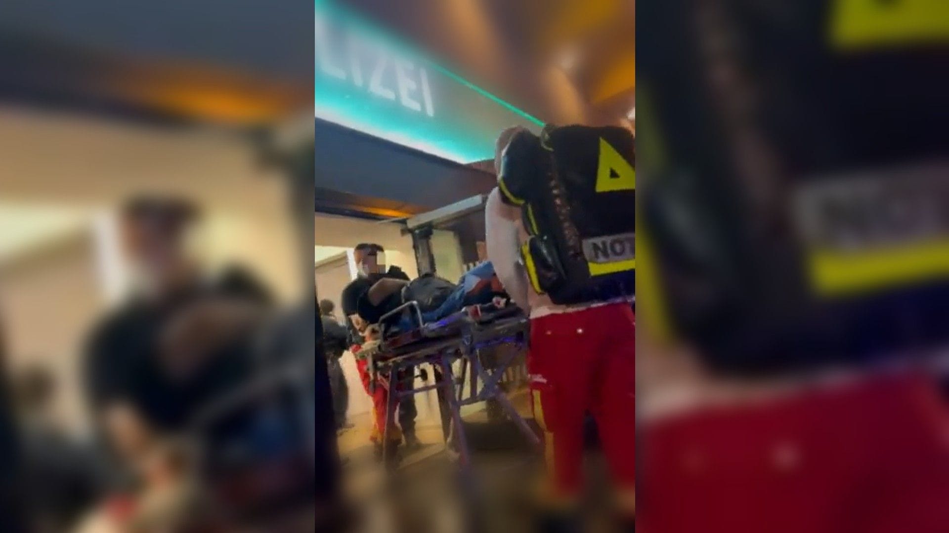 Eine Szene aus dem Video: Der Mann wird auf einer Trage aus der Polizeiwache in Berlin transportiert. Eine Szene aus dem Video: Der Mann wird auf einer Trage aus der Polizeiwache in Berlin transportiert.