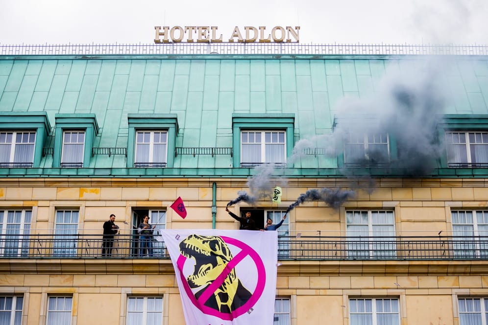 Aktivisten von "Extinction Rebellion" stehen auf einer Balustrade des Hotel Adlon: Die Gruppe hat ein Protestcamp im Invalidenpark aufgebaut.