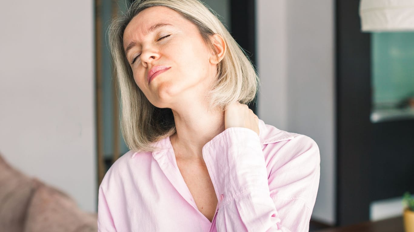 Frau hat Nackenschmerzen: Fehlhaltungen am Arbeitsplatz bekommt man schnell im Nacken oder im Rücken zu spüren.