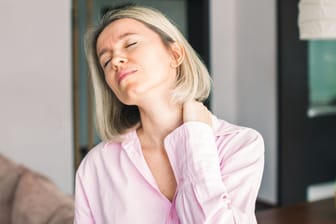 Frau hat Nackenschmerzen: Fehlhaltungen am Arbeitsplatz bekommt man schnell im Nacken oder im Rücken zu spüren.