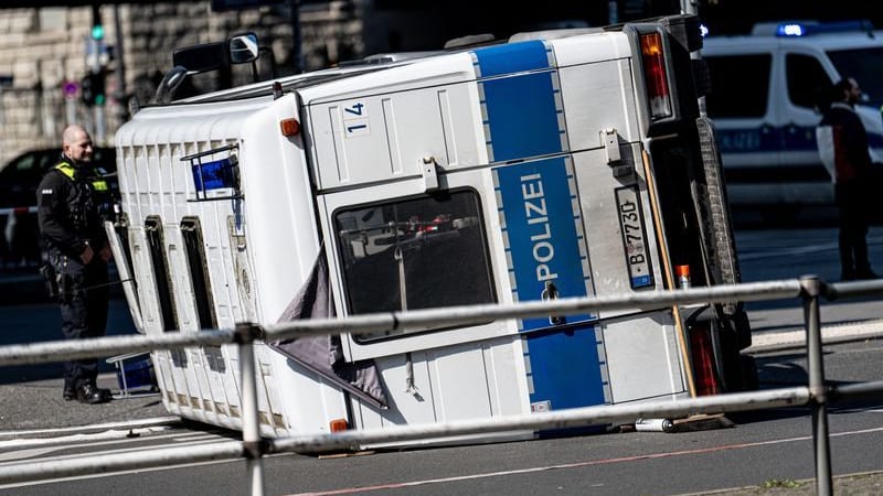 Ein umgekipptes Polizeifahrzeug liegt nach einem Unfall vor dem Bahnhof Zoo auf einer Kreuzung.