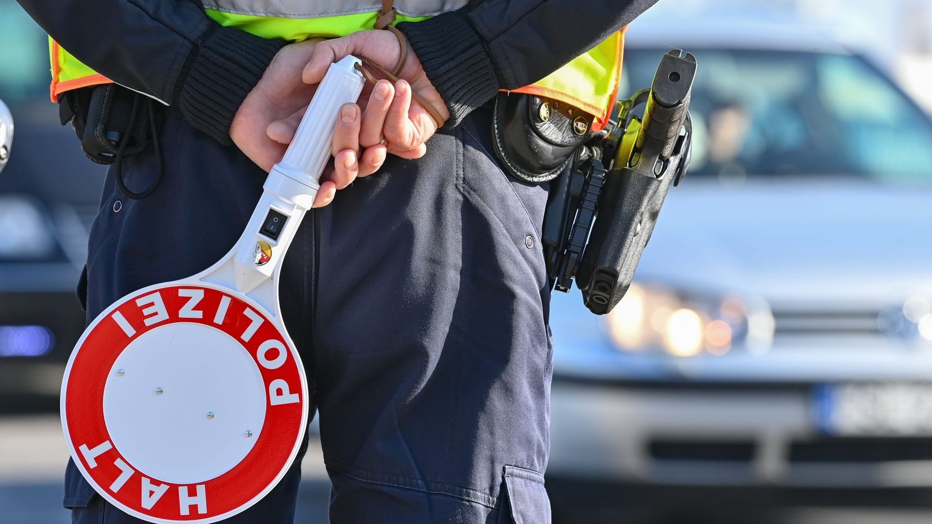 Ein Polizist hält eine Winkerkelle in den Händen (Symbolbild): Im Landkreis Hildesheim musste ein 28-Jähriger seinen Weg statt mit dem Auto zu Fuß fortsetzen.