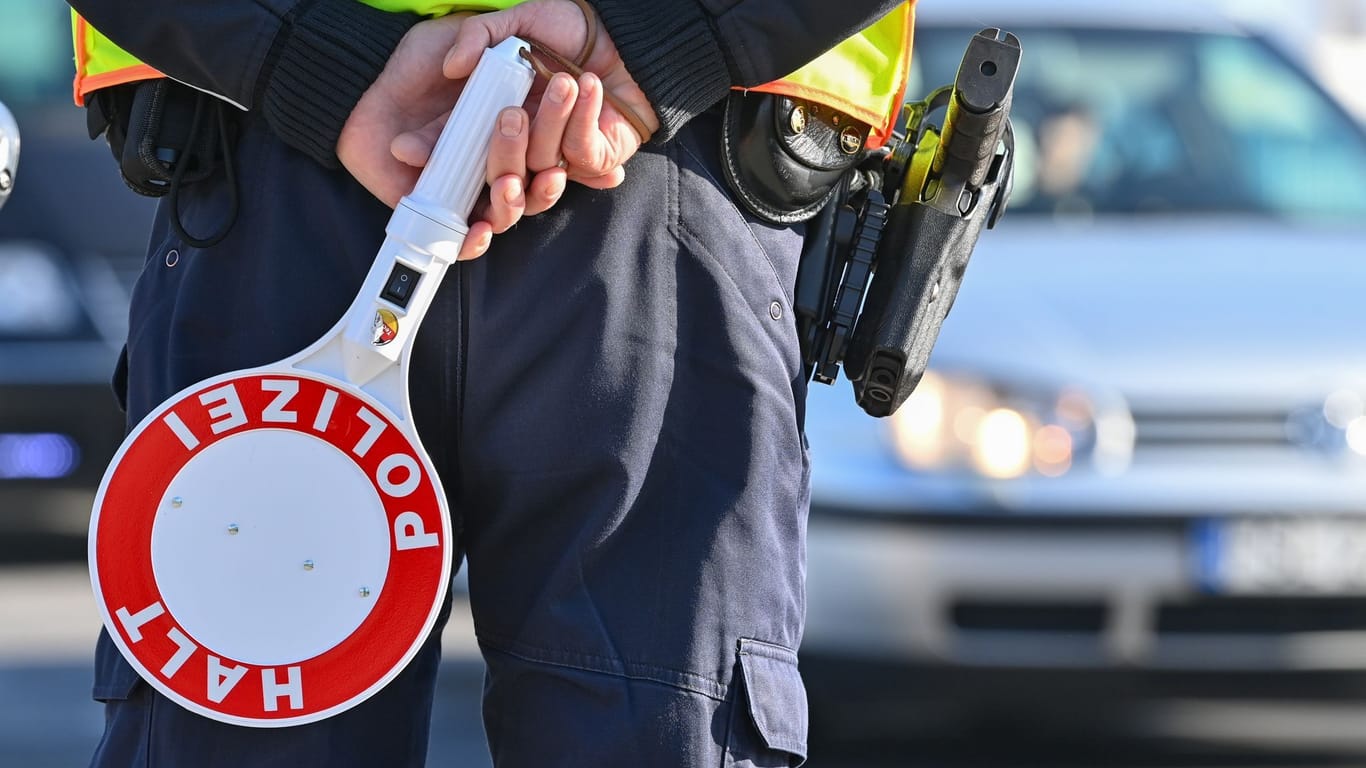 Ein Polizist hält eine Winkerkelle in den Händen (Symbolbild): Im Landkreis Hildesheim musste ein 28-Jähriger seinen Weg statt mit dem Auto zu Fuß fortsetzen.