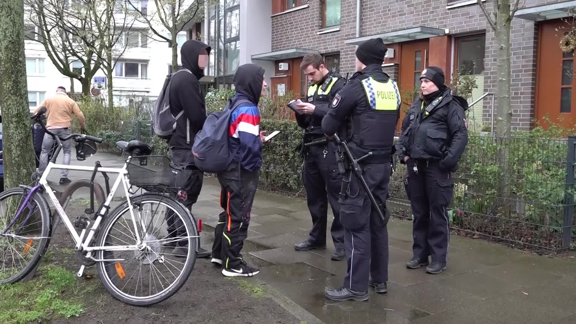 Polizisten sprechen mit Jugendlichen vor dem Haus in Hamburg: An der Adresse sollte angeblich eine Party stattfinden, diese war jedoch nie geplant.