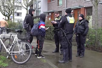 Polizisten sprechen mit Jugendlichen vor dem Haus in Hamburg: An der Adresse sollte angeblich eine Party stattfinden, diese war jedoch nie geplant.