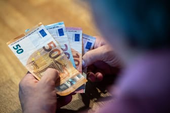 Ein Mann hält Geldscheine (Symbolbild): Die Mehrheit der Menschen in Deutschland fürchtet im Alter um den gewohnten Lebensstandard.