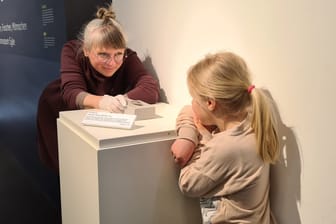 Die fünfjährige Levke, stolze Finderin des Dolchs, mit Nele Miethig, Kuratorin der archäologischen Sammlung des Kreismuseums Syke.