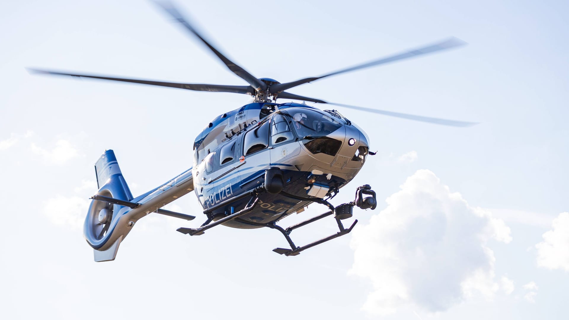 Ein Polizeihubschrauber fliegt in der Nacht (Symbolbild): Mithilfe eines Hubschraubers fanden die Beamten die Männer auf einem Baum und in einem Gebüsch.