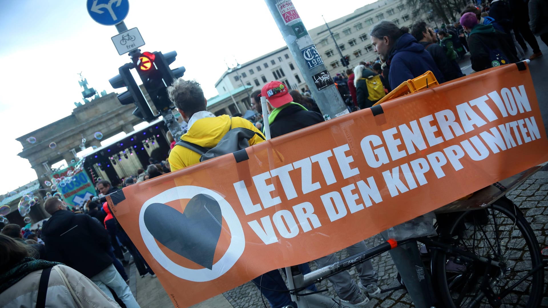 Klima-Demonstration und Konzert vor dem Brandenburger Tor in Berlin anlässlich des Volksentscheids Berlin 2030 Klimaneutral - Berlin, GER, Germany, Deutschland 25.03.2023 - Berlin-Mitte: Am Tag vor dem Volksentscheid in Berlin demonstrieren Menschen für eine konsequentere Bekämpfung der Klimakatastrophe bei einer Kundgebung mit diversen Konzerteinlagen. Beteiligte Aktivistinnen und Aktivisten sowie Organisationen rufen die Menschen immer wieder auf, am Sonntag beim Volksentscheid mit Ja abzustimmen, um damit zu erreichen, dass Berlin 15 Jahre früher als geplant statt 2045 bis 2030 klimaneutral wird. Besucher auf der Straße des 17. Juni verfolgen die Klima-Veranstaltung, teils auch bei immer wieder einsetzenden kräftigen Regenschauern. B