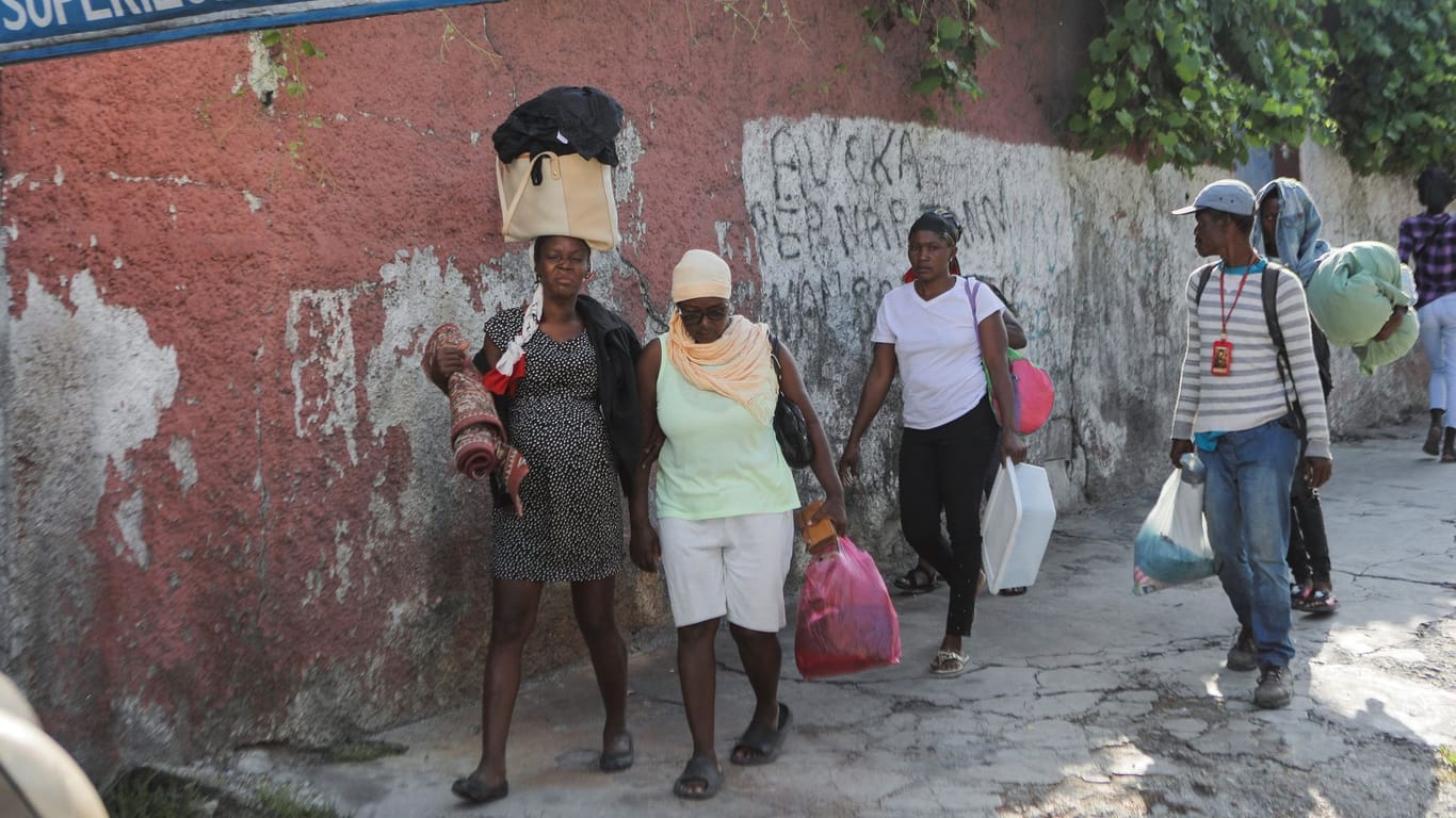 Frauen und Kinder fliehen aus gefährlichen Stadtviertel in Haiti.