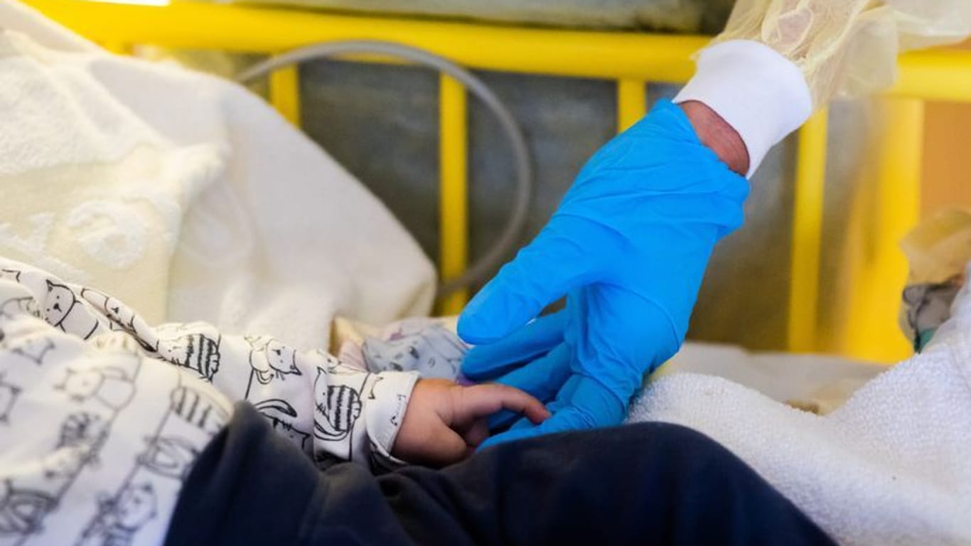 Eine Ärztin untersucht ein Kind in einer Klinik (Symbolbild): Eine Analyse zeigt den Grund der erhöhten RSV-Infektionen bei Kindern in Bayern.