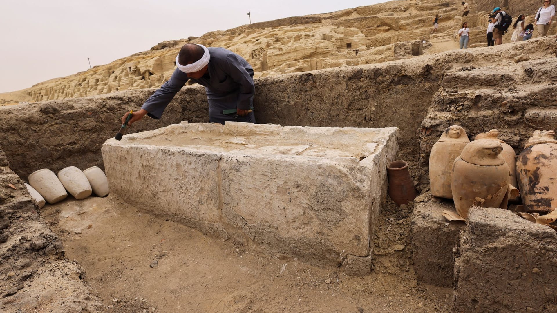 Ein Arbeiter reinigt eines der Steinbetten in einer Mumienwerkstatt, die jetzt nahe Kairo entdeckt wurde. Ein Arbeiter reinigt eines der Steinbetten in einer Mumienwerkstatt, die jetzt nahe Kairo entdeckt wurde.