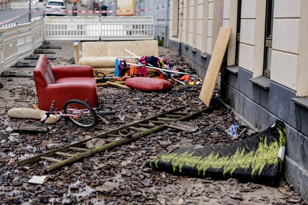 Hausrat und ein Fahrrad liegen in der Flensburger Neustadt an einem Mehrfamilienhaus: Ein Kind und ein Erwachsener fielen dem Brand zum Opfer.