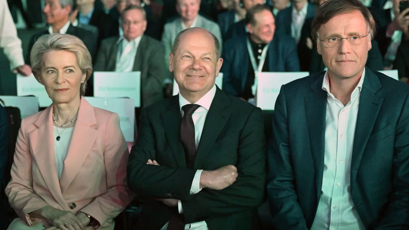 Bundeskanzler Olaf Scholz (SPD, M), Ursula von der Leyen, EU- Kommissionspräsidentin (l), und Jochen Hanebeck, Vorstandsvorsitzender von Infineon, sitzen beim Spatenstich für die Smart Power Fab von Infineon in Dresden in der ersten Reihe.