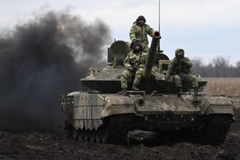 Russische Soldaten sitzen auf einem T-90M Kampfpanzer in der von Russland besetzten Ukraine.