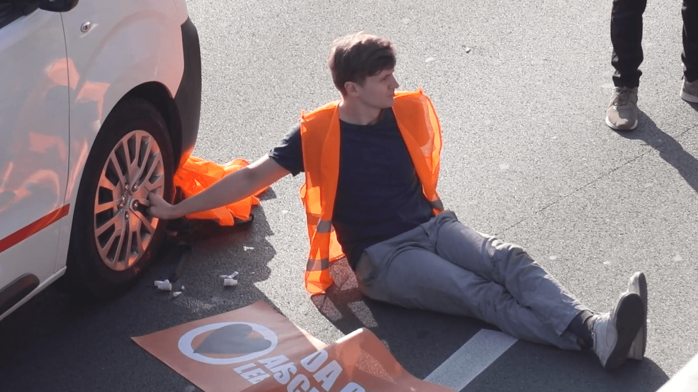 Ein Aktivist klebte an einem Autoreifen: An zahlreichen Orten in Berlin blockierte die "Letzte Generation" Straßen.