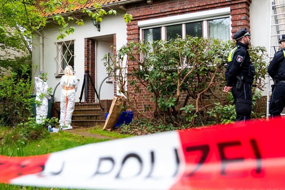 Polizisten und Mitarbeiter der Spurensicherung stehen im Stadtteil Blankenese vor einem Wohnhaus. Dort wurde die Leiche einer Frau gefunden.