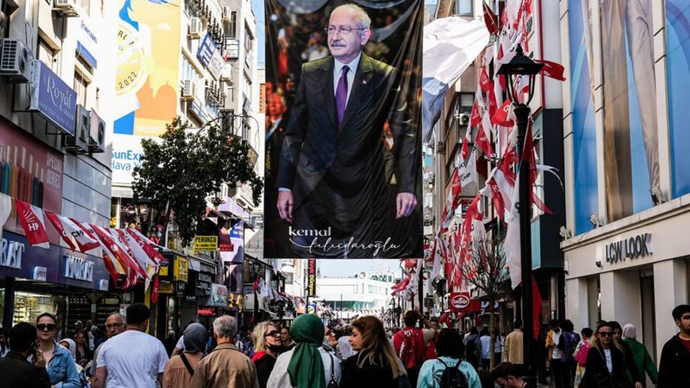 Izmir: Menschen spazieren unter einem großen Plakat von Kemal Kilicdaroglu vorbei. 60,7 Millionen Wahlberechtigte in der Türkei sind aufgerufen, am 14. Mai 2023 einen Präsidenten und ein neues Parlament zu wählen.