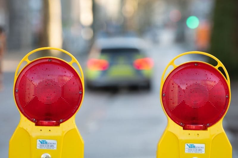 Ein Polizeiwagen fährt durch ein wegen einer Bombenentschärfung gesperrtes Viertel (Symbolbild): Die Kosten für die Kampfmittelbeseitigung sind hoch.