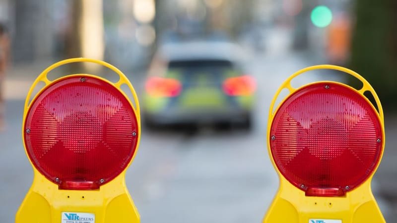 Ein Polizeiwagen fährt durch ein wegen einer Bombenentschärfung gesperrtes Viertel (Symbolbild): Die Kosten für die Kampfmittelbeseitigung sind hoch.