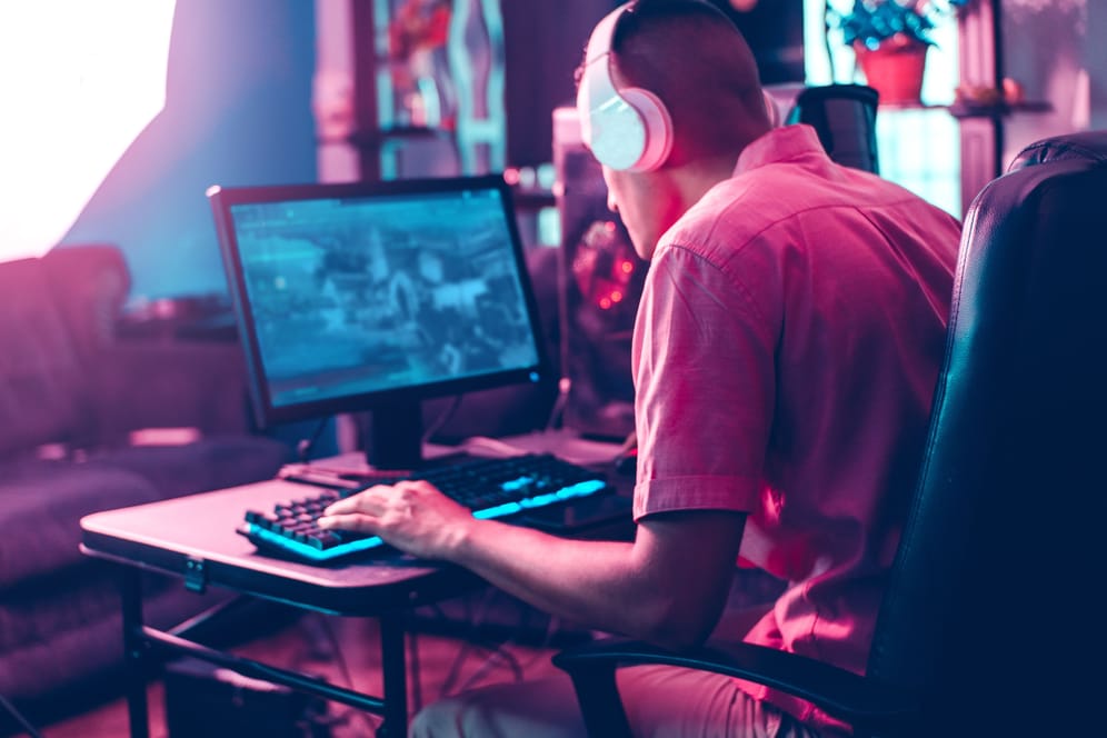 Ein Mann spielt am Computer (Symbolbild): Er trug ein Headset und war sich der eigenen Lautstärke offenbar nicht bewusst.