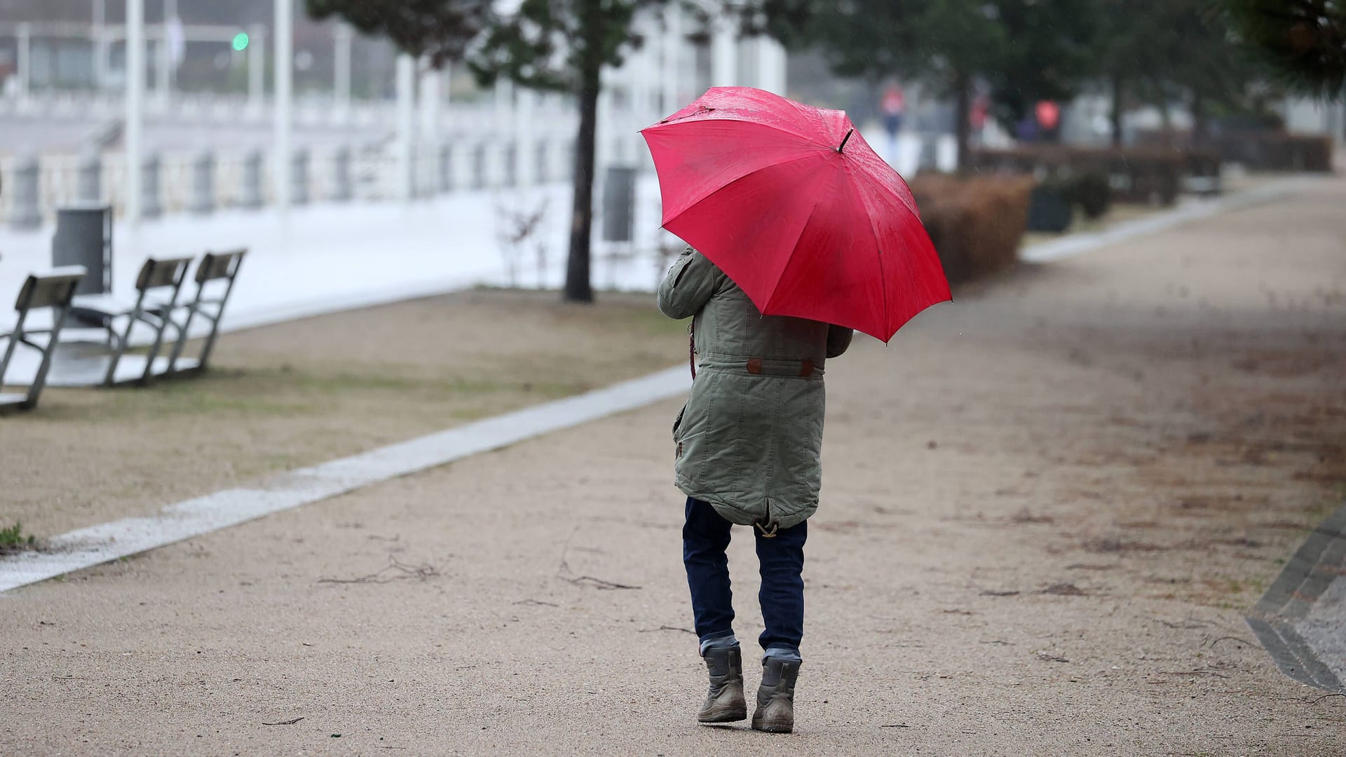 Eine Spaziergängerin auf der Promenade in Travemünde: Auch bei leichtem Regen kann ein Spaziergang schön sein.