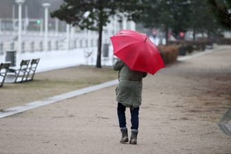 Eine Spaziergängerin auf der Promenade in Travemünde: Auch bei leichtem Regen kann ein Spaziergang schön sein.