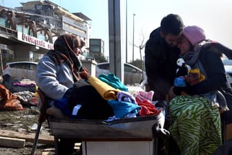 Drei Personen sitzen in den Trümmern nach dem Erdbeben 2023 in der Türkei: Eine neue Studie zeigt, wie wir besser mit schlechten Nachrichten umgehen können.