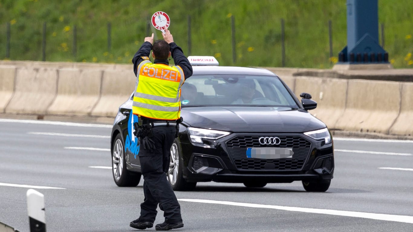 Polizist bei Fahrzeugkontrolle (Symbolbild): Die mutmaßlichen Tresordiebe sind weiterhin auf der Flucht.