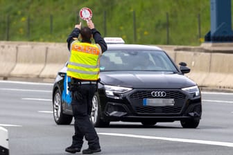 Polizist bei Fahrzeugkontrolle (Symbolbild): Die mutmaßlichen Tresordiebe sind weiterhin auf der Flucht.