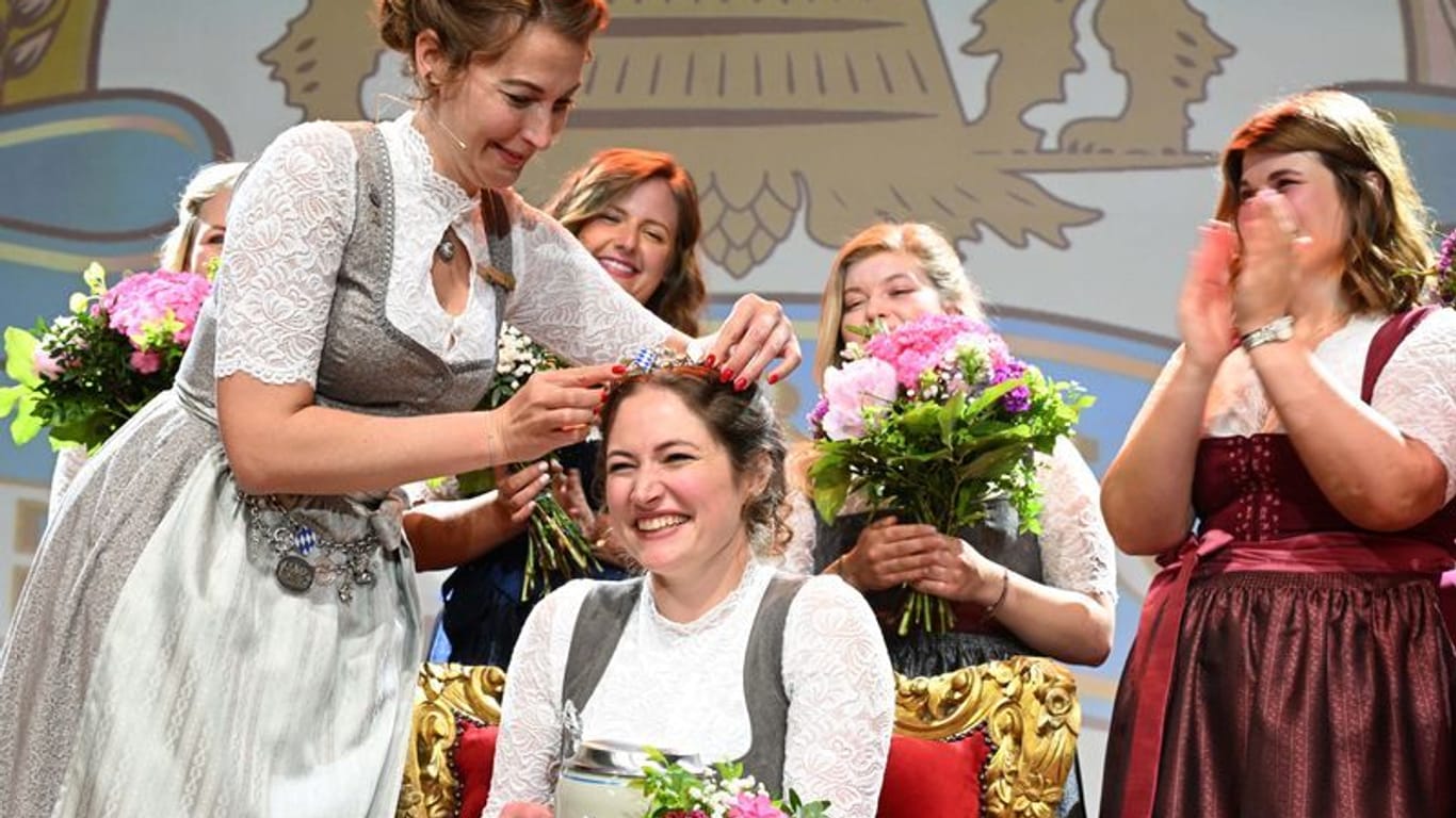 Die ehemalige bayerische Bierkönigin Sarah Jäger übergibt Mona Sommer (2.v.l) die Königskrone: Die Siegerin konnte sich gegen sechs Finalistinnen durchsetzen.
