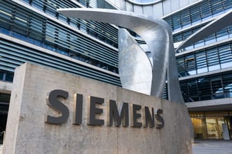 Der Schriftzug "Siemens" ist vor der Firmenzentrale erkennbar (Symbolbild): Konzernchef Roland Busch rechnet trotz positiver Geschäftsjahresprognose mit vorerst weniger Erfolgsschwung.