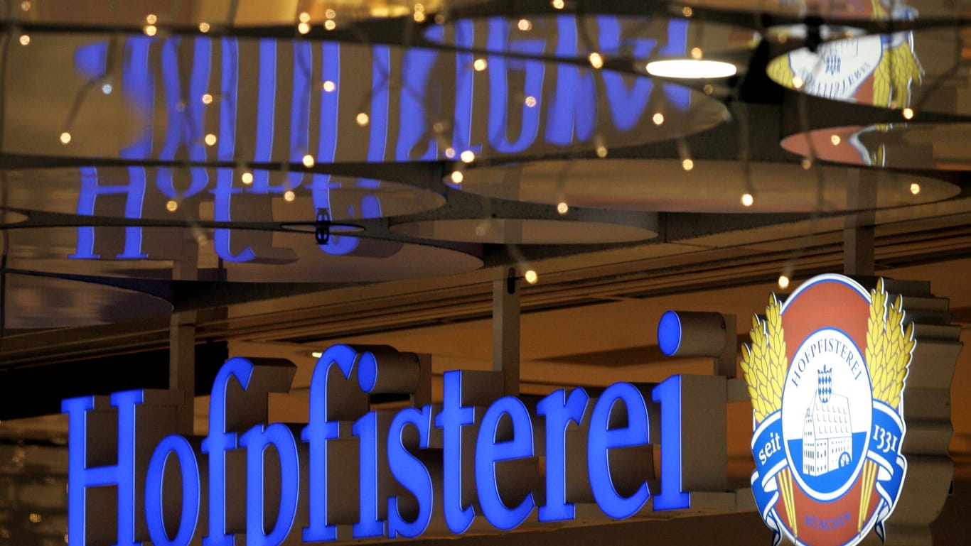 Schriftzug und Logo Hofpfisterei spiegeln sich an einer Deckenverkleidung in einer Einkaufspassage in der Innenstadt München.