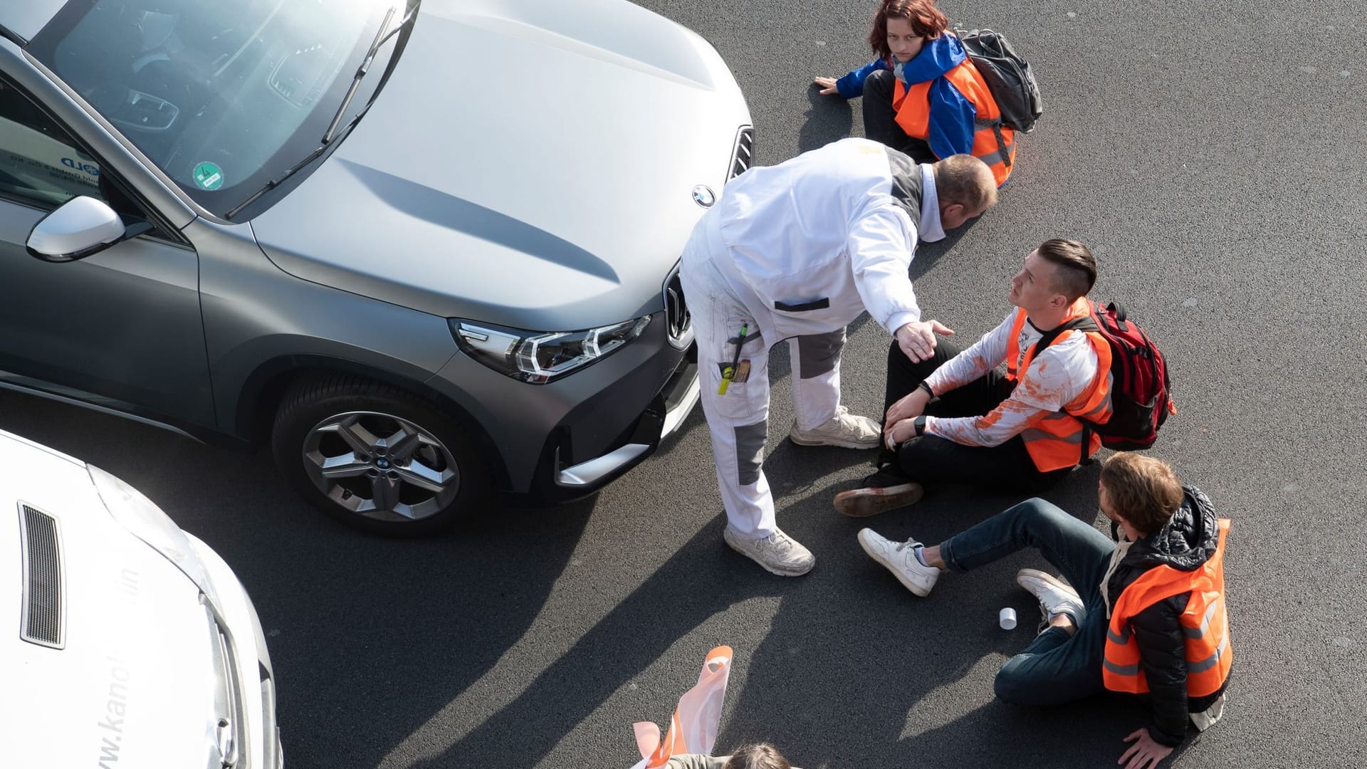 Ein Mann redet bei einer Blockade auf Aktivisten ein (Archivbild): Immer wieder kommt es zu Konfrontationen zwischen Autofahrern und der "Letzten Generation".