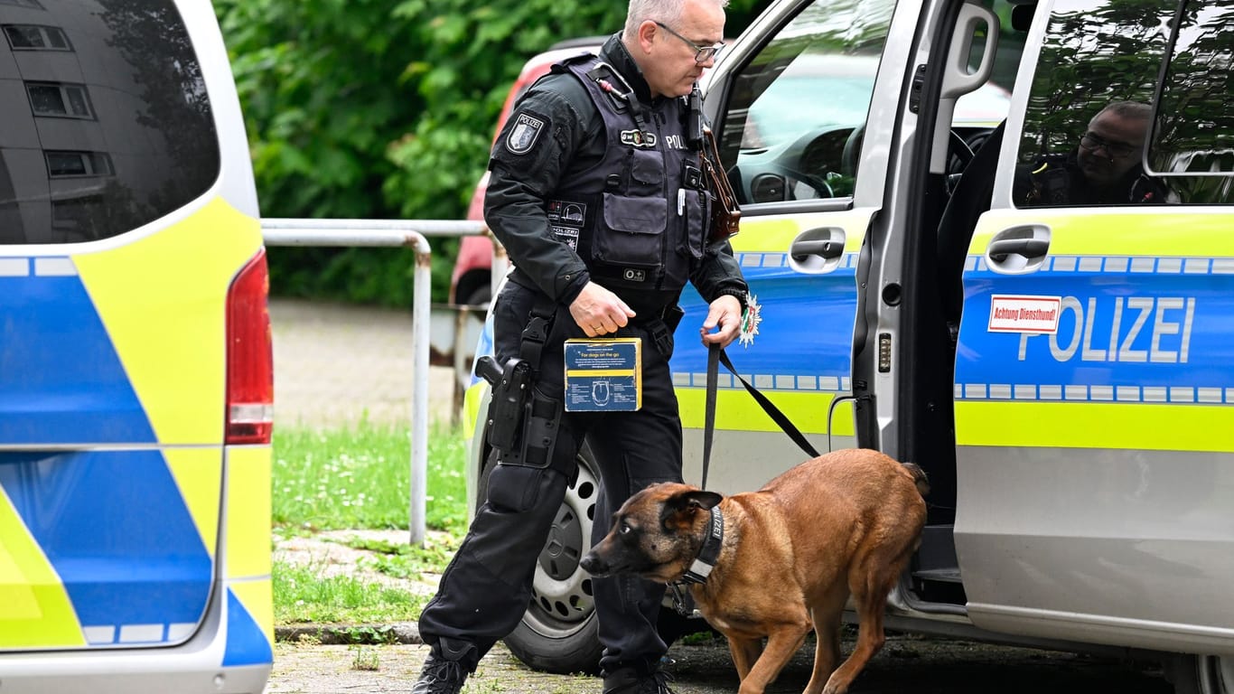 Ratingen: Ein Polizist führt einen Spurensuchhund an den Tatort.