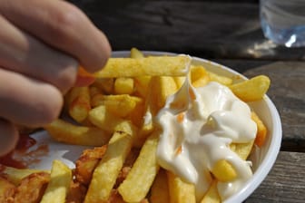 Ein Kind isst Pommes Frites (Archivbild): In Niedersachsen steigt die Zahl übergewichtiger Kinder.
