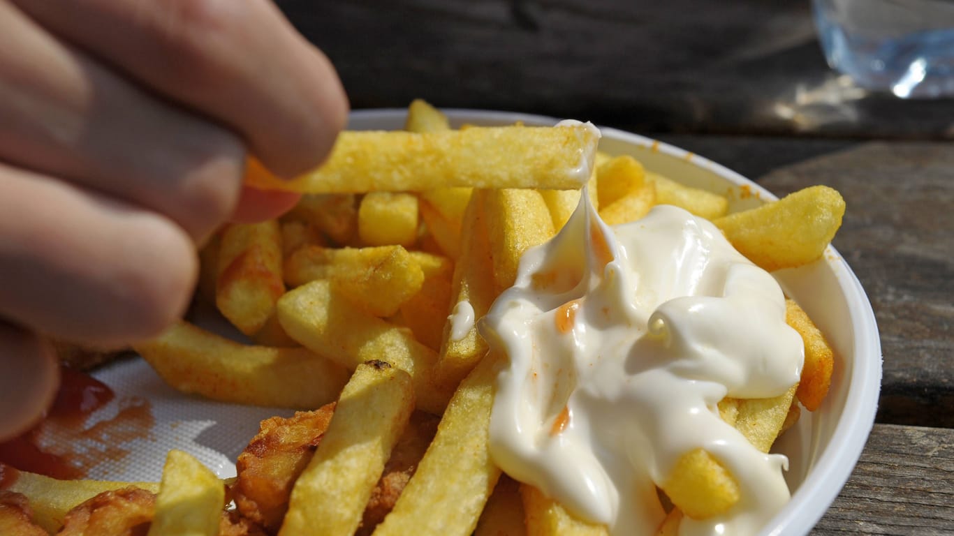 Ein Kind isst Pommes Frites (Archivbild): In Niedersachsen steigt die Zahl übergewichtiger Kinder.