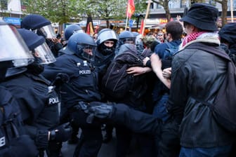 Ein Polizist tritt nach einem Passanten: Insbesondere am Abend kam es in Kreuzberg zu Auseinandersetzungen zwischen Beamten und Passanten.
