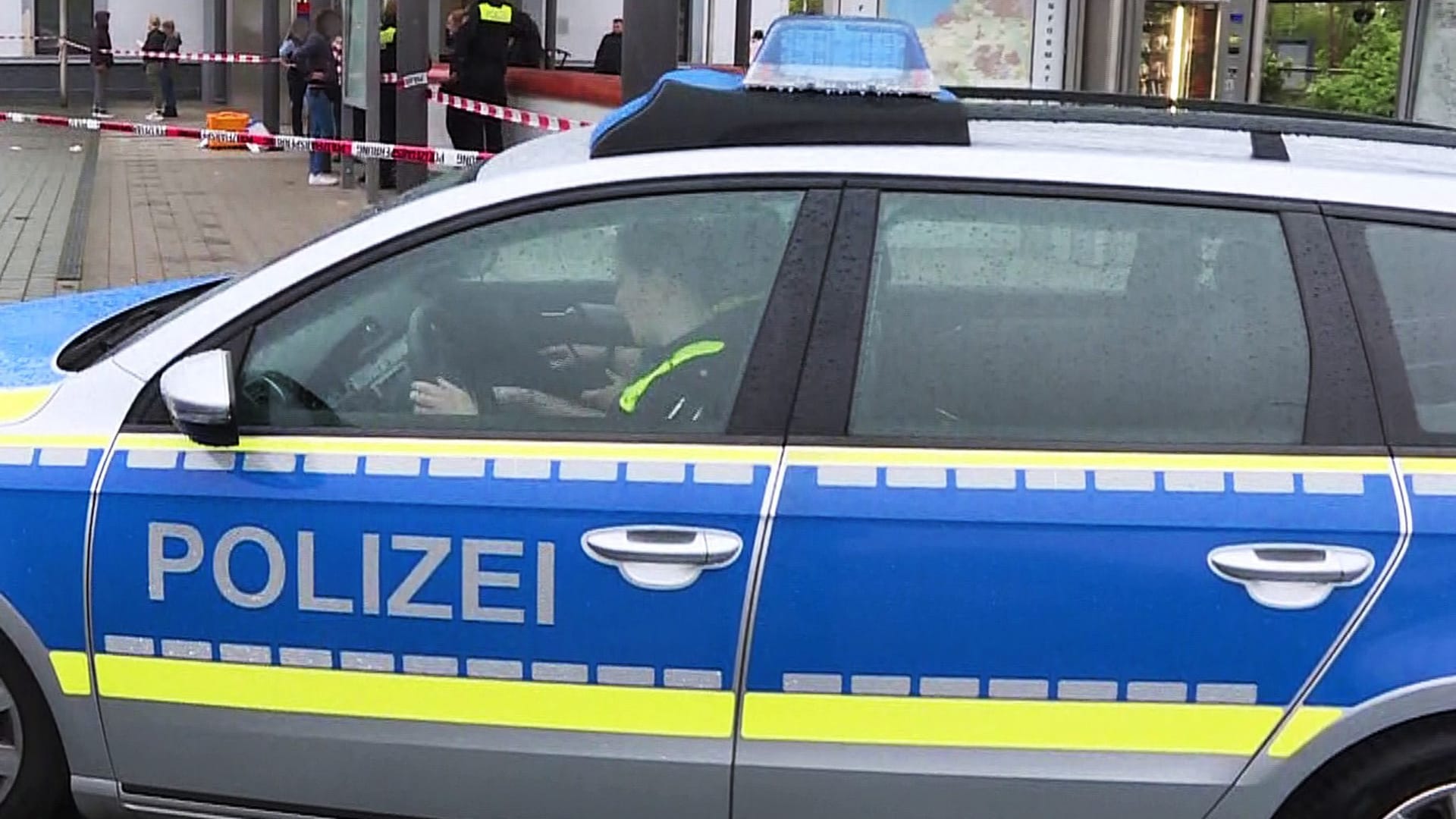 Polizisten sitzen in einem Polizeiauto am Bahnhof in Wunstorf: Hier ist es am Freitag zu einer Messerattacke gekommen.