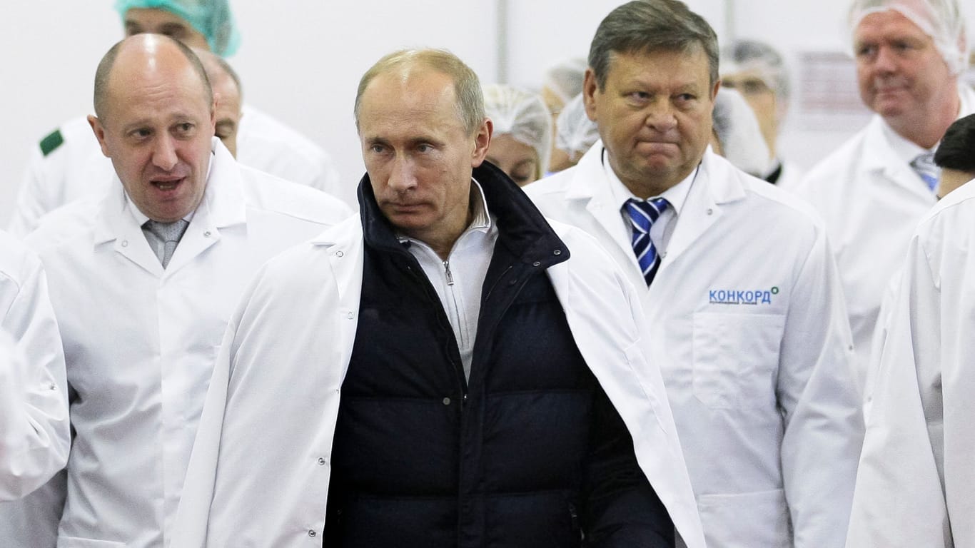 Diktator Wladimir Putin (M.) bei der Besichtigung einer von Prigoschins (l.) Fabriken in St. Petersburg im Jahr 2010.