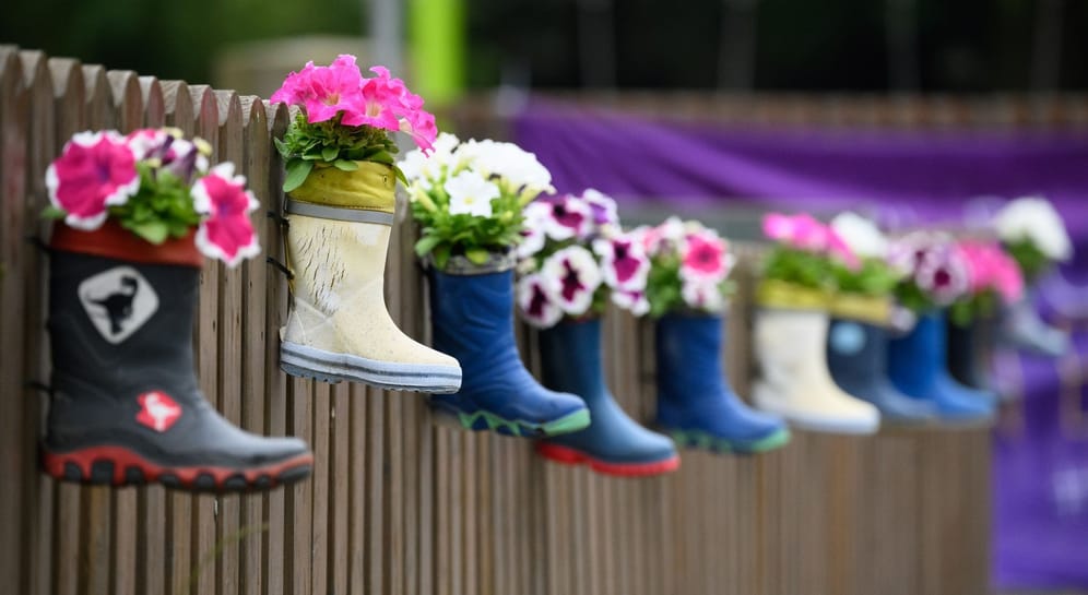 Kinder-Gummistiefel mit Blumen hängen an einem Zaun einer Kindertagesstätte (Symbolbild): Bei einer Fachkonferenz in Hannover wurde über den Personalmangel in Kitas gesprochen.